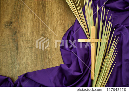 Palm sunday cross and fronds on purple fabric Palm sunday cross and fronds on purple fabric 137042358