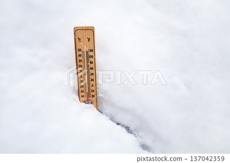 Thermometer showing freezing temperatures in fresh snow Thermometer showing freezing temperatures in fresh snow 137042359