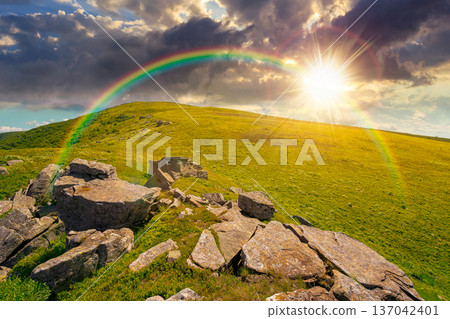 sunset over rocks and rolling hills in mountain landscape in summer. scenery with green grass on alpine meadow under sky with clouds. background for recreation tourism and wanderlust under the rainbow sunset over rocks and rolling hills in mountain landscape in summer. scenery with green grass on alpine meadow under sky with clouds. background for recreation tourism and wanderlust under the rainbow 137042401