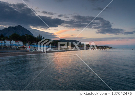KEMER, TURKEY - 28 MAY 2025: An evening sea landscape at a resort in the Kemer region with colourful sky over mountains. The view shows hotels along the beachfront with Mountains  137042476