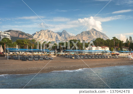 A beautiful seascape of a beach with a resort hotel in the Kemer region of Turkey. A sunny morning with the Taurus Mountains visible on the horizon. A beautiful seascape of a beach with a resort hotel in the Kemer region of Turkey. A sunny morning with the Taurus Mountains visible on the horizon. 137042478
