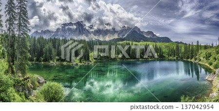The emerald green Lake Carezza reflecting Latemar mountain, Dolomites, Italy The emerald green Lake Carezza reflecting Latemar mountain, Dolomites, Italy 137042954