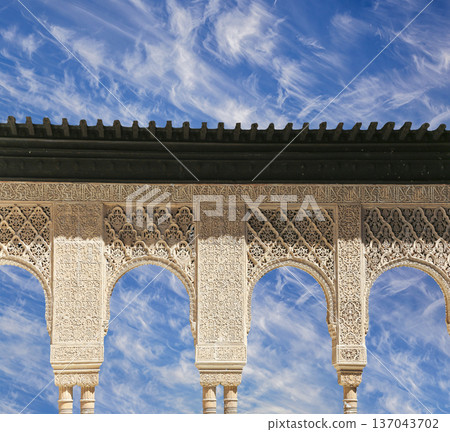 Arches in Islamic (Moorish) style (against the background of a beautiful sky with clouds) in Alhambra, Granada, Spain 137043702