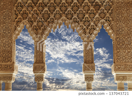 Arches in Islamic (Moorish) style (against the background of a beautiful sky with clouds) in Alhambra, Granada, Spain 137043721