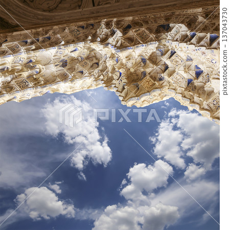 Arches in Islamic (Moorish) style (against the background of a beautiful sky with clouds) in Alhambra, Granada, Spain 137043730