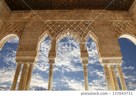 Arches in Islamic (Moorish) style (against the background of a beautiful sky with clouds) in Alhambra, Granada, Spain 137043731