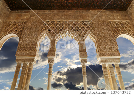 Arches in Islamic (Moorish) style (against the background of a beautiful sky with clouds) in Alhambra, Granada, Spain 137043732