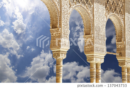 Arches in Islamic (Moorish) style (against the background of a beautiful sky with clouds) in Alhambra, Granada, Spain Arches in Islamic (Moorish) style (against the background of a beautiful sky with clouds) in Alhambra, Granada, Spain 137043733