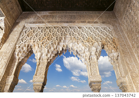 Arches in Islamic (Moorish) style (against the background of a beautiful sky with clouds) in Alhambra, Granada, Spain 137043742