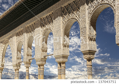 Arches in Islamic (Moorish) style (against the background of a beautiful sky with clouds) in Alhambra, Granada, Spain 137043751