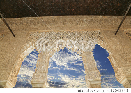 Arches in Islamic (Moorish) style (against the background of a beautiful sky with clouds) in Alhambra, Granada, Spain Arches in Islamic (Moorish) style (against the background of a beautiful sky with clouds) in Alhambra, Granada, Spain 137043753