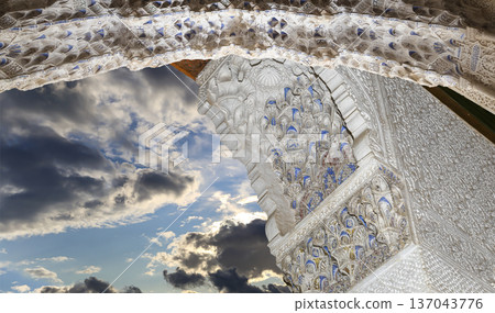 Arches in Islamic (Moorish) style (against the background of a beautiful sky with clouds) in Alhambra, Granada, Spain Arches in Islamic (Moorish) style (against the background of a beautiful sky with clouds) in Alhambra, Granada, Spain 137043776