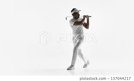 Golfer holding finish position with club across shoulders on white background. Golfer holding finish position with club across shoulders on white background. 137044217