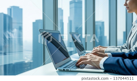 一位商務人士在辦公室操作筆記型電腦的雙手 137044511