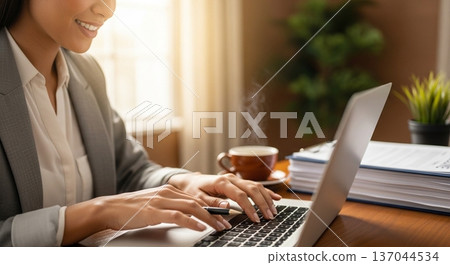 一位商務人士在辦公室操作筆記型電腦的雙手 137044534
