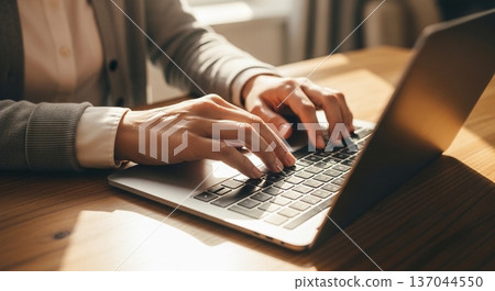 一位商務人士在辦公室操作筆記型電腦的雙手 137044550