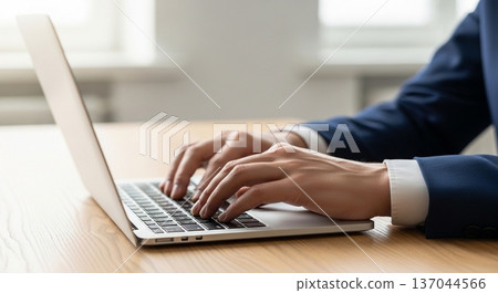 一位商務人士在辦公室操作筆記型電腦的雙手 137044566