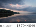 Water mirror with reflecting heaven on surface at morning sunrise. Beautiful lakescape of nature with lake and wild forest on the coast. 137044649