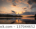 Amazing landscape of lake at colourful sunset with gold clouds as mirror on the surface of water with awasome reflections 137044652