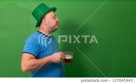 Man in green leprechaun hat holding frothy beer pint. Side profile view of bearded male celebrating St. Patricks Day. Irish holiday tradition with festive pub culture and cheerful spirit. photography Man in green leprechaun hat holding frothy beer pint. Side profile view of bearded male celebrating St. Patricks Day. Irish holiday tradition with festive pub culture and cheerful spirit. photography 137045843