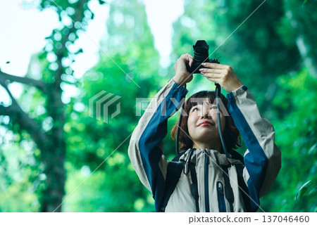 Young woman hiking in green space and taking photos Young woman hiking in green space and taking photos 137046460