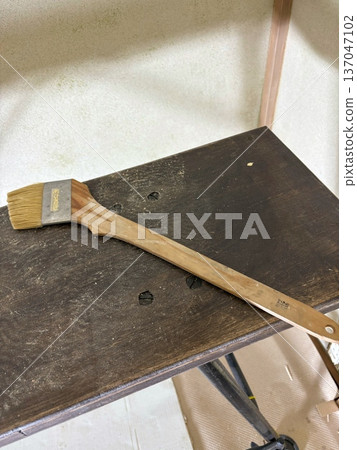 A well-used plasterer's brush, a tool on a workbench 137047102