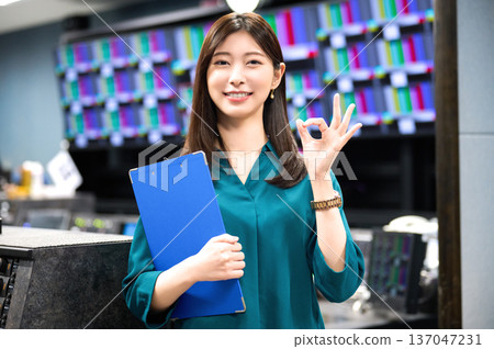 A smiling Japanese woman giving the OK sign in a broadcasting studio. Photo courtesy of Sky Perfect TV Tokyo Media Center. 137047231