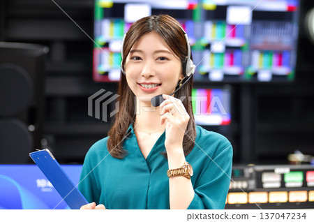 一位微笑的女導演戴著對講機在廣播攝影棚裡發出指令。影片由Sky Perfect TV東京媒體中心提供。 137047234