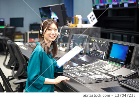 一位女導演正在廣播攝影棚透過對講機發出指令。拍攝合作：Sky Perfect 東京媒體中心 137047235