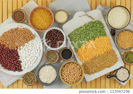Variety of protein products and different grain for vegetarians. Soy, lentils, peas, chickpeas, beans, bulgur, rice and oatmeal in bowls. Top view. 137047296