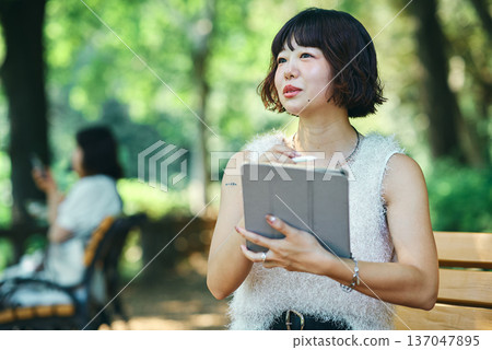 Young woman using a tablet PC outdoors 137047895