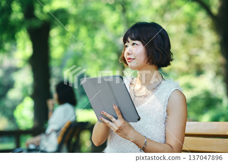 年輕女子在戶外使用平板電腦 年輕女子在戶外使用平板電腦 137047896