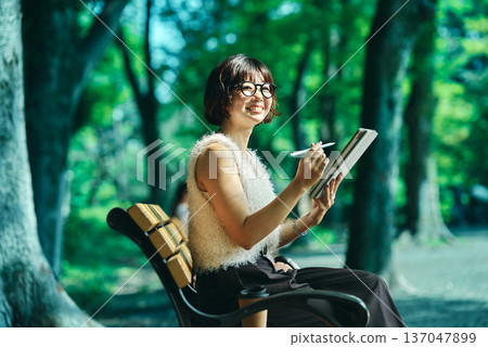 Young woman using a tablet PC outdoors 137047899