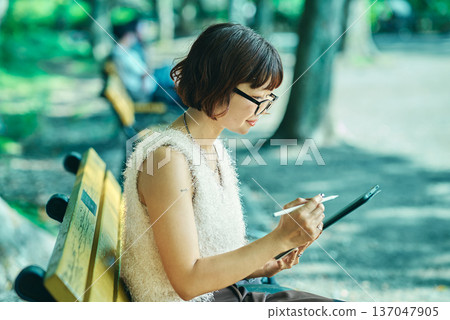 年輕女子在戶外使用平板電腦 年輕女子在戶外使用平板電腦 137047905