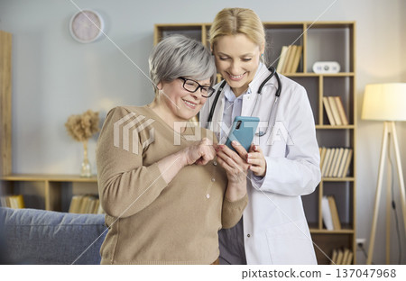 Senior woman and female doctor using smartphone for online guidance and support 137047968