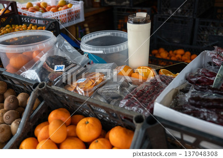 Market stall with churchkhela sweets, mandarins, kiwifruit, and citrus fruits arranged in crates with natural colors and rustic textures. Food marketing, culinary tourism, local product promotion 137048308