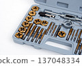 Professional tap and die set with titanium coating for thread cutting in a gray storage case. 137048334