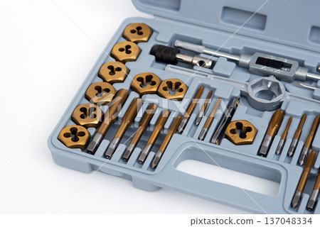 Professional tap and die set with titanium coating for thread cutting in a gray storage case. Professional tap and die set with titanium coating for thread cutting in a gray storage case. 137048334