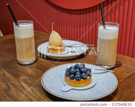 Two Latte Coffee Cups with Blueberry Pear Shaped Dessert Two Latte Coffee Cups with Blueberry Pear Shaped Dessert 137048610