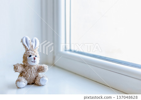 soft toy little bunny on an empty windowsill soft toy little bunny on an empty windowsill 137048628