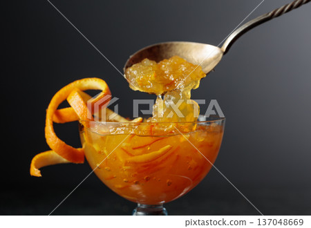 Orange dessert in a glass bowl garnished with orange peel. 137048669