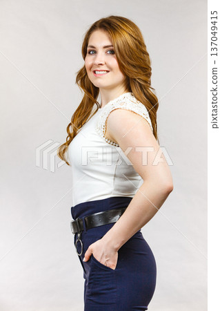 Woman wearing high waist trouser with belt Woman wearing high waist trouser with belt 137049415