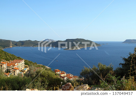 View from the bird's eye of the Kas city district of Antalya Province of Turkey Asia. Colorful spring sunset in small Mediterranean yachting and tourist town. View from the bird's eye of the Kas city district of Antalya Province of Turkey Asia. Colorful spring sunset in small Mediterranean yachting and tourist town. 137049457