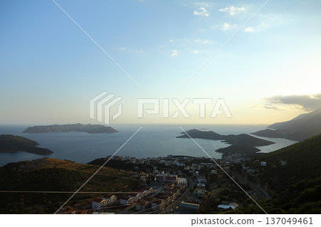 View from the bird's eye of the Kas city district of Antalya Province of Turkey Asia. Colorful spring sunset in small Mediterranean yachting and tourist town. View from the bird's eye of the Kas city district of Antalya Province of Turkey Asia. Colorful spring sunset in small Mediterranean yachting and tourist town. 137049461