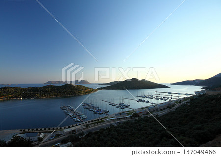 View from the bird's eye of the Kas city district of Antalya Province of Turkey Asia. Colorful spring sunset in small Mediterranean yachting and tourist town. View from the bird's eye of the Kas city district of Antalya Province of Turkey Asia. Colorful spring sunset in small Mediterranean yachting and tourist town. 137049466