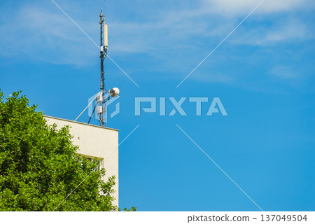 Cellular network antenna against blue sky. 137049504
