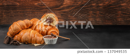 Croissants with chocolate filling and spread on rustic table 137049535