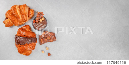 Chocolate croissants with hazelnut spread and chocolate pieces, top view with copy space Chocolate croissants with hazelnut spread and chocolate pieces, top view with copy space 137049536