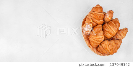 Fresh croissants in wicker basket on white background with copy space Fresh croissants in wicker basket on white background with copy space 137049542