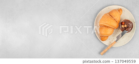 Croissant with chocolate spread and knife on plate, top view with copy space Croissant with chocolate spread and knife on plate, top view with copy space 137049559